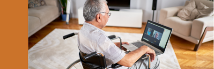 Elderly man in wheelchair talking to doctors on his laptop