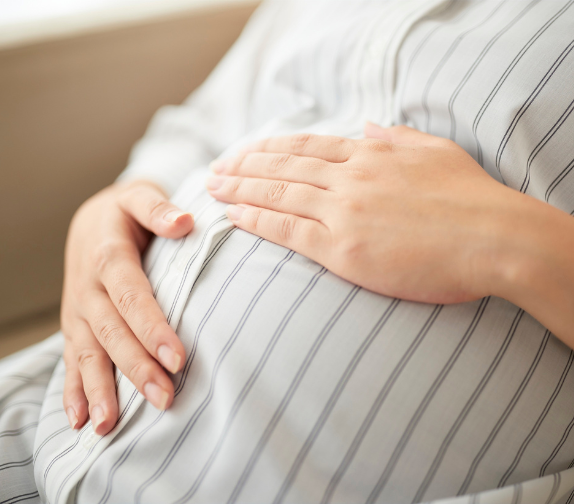 a closeup of a person's hands on their pregnant belly