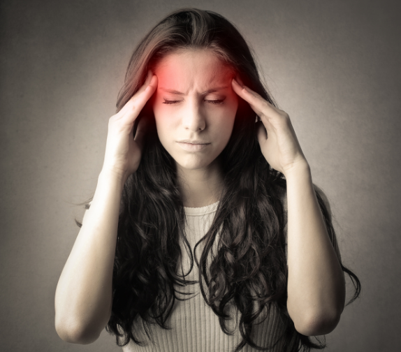 a woman presses on her temples in pain