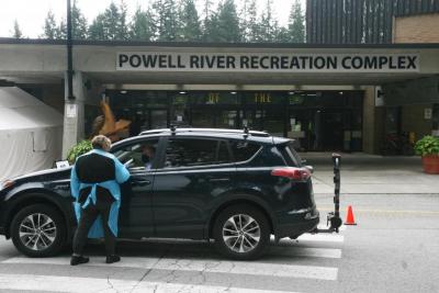 Healthcare worker helping person in car outside Powell River COVID-19 Assessment Clinic