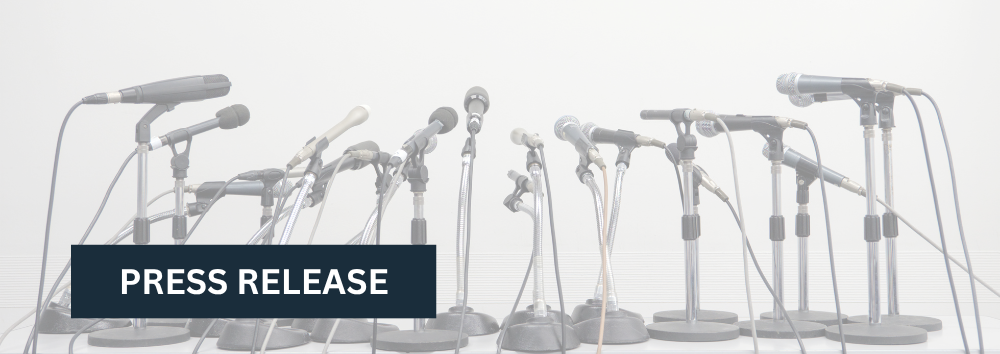 Press Release. Background image is a row of microphones all pointing in the same direction.