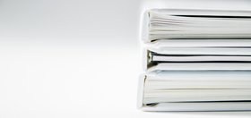 Closeup of two white books stacked with a white background.