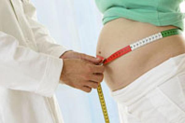 Physician measuring pregnant woman's belly